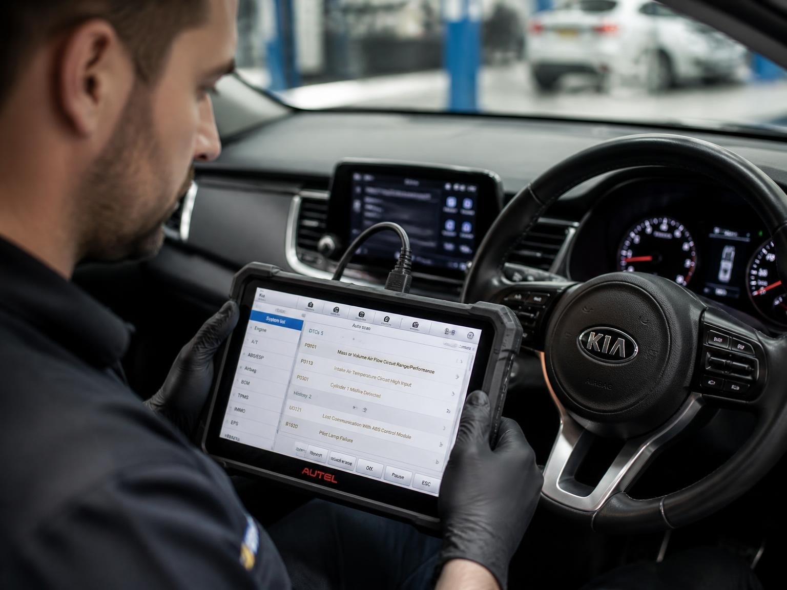 Auto mechanic using vehicle diagnostic equipment