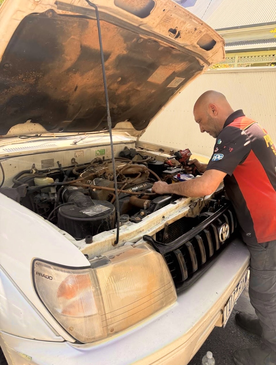 Mobile Mechanic Working on Car in Driveway