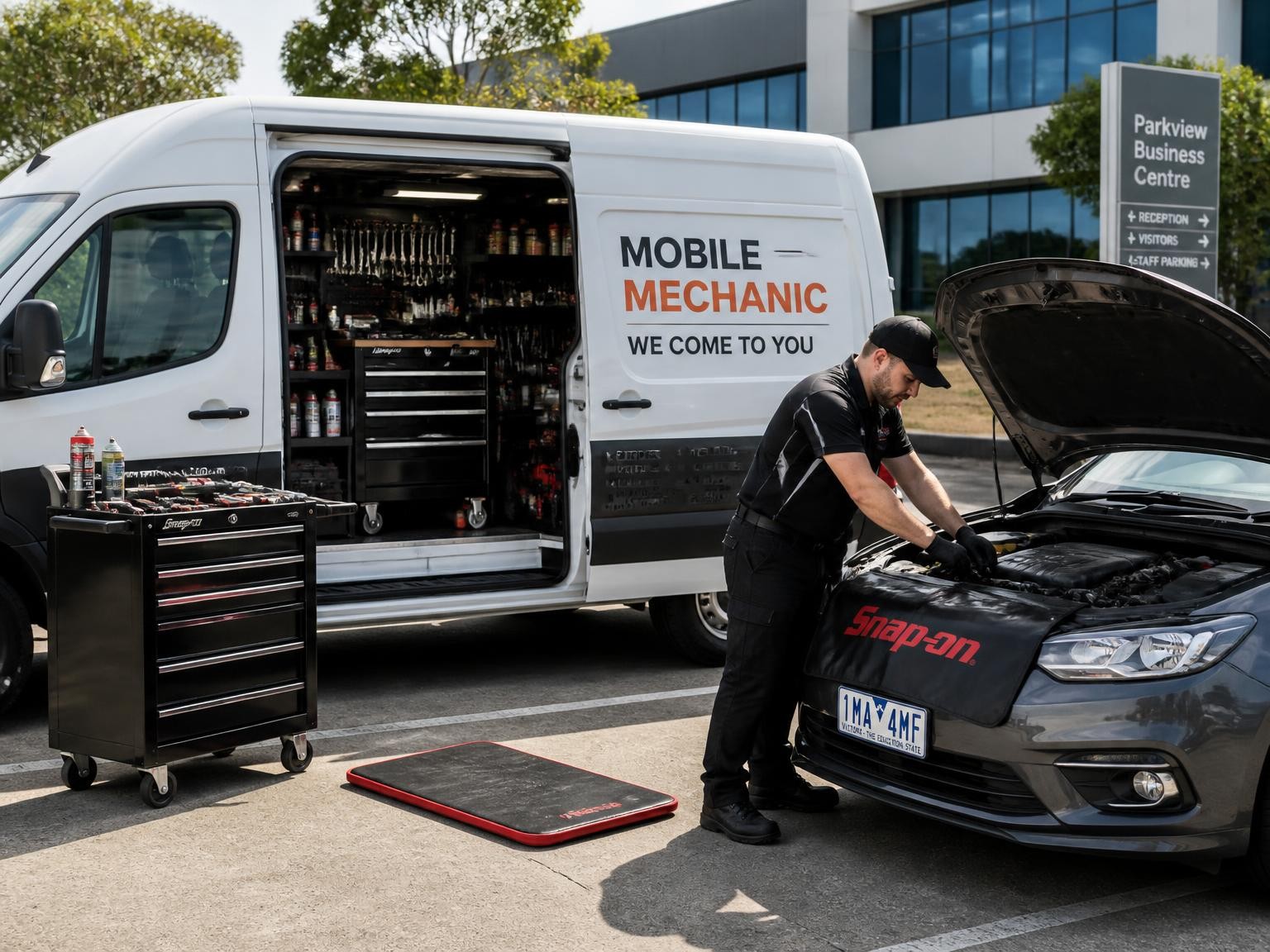 Mobile mechanic servicing a car at a Melbourne workplace